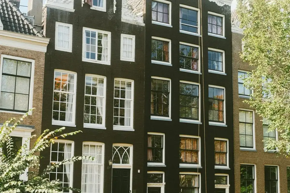 Gevels van oude bakstenen grachtenhuizen met witte ramen