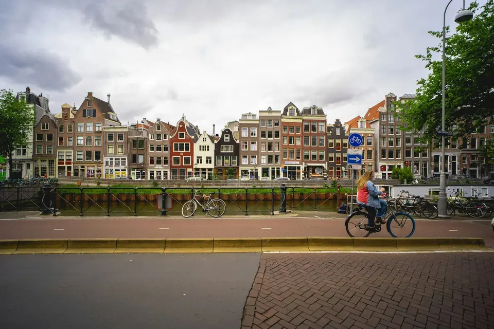 Een gracht met oude huizen en een fietser op de voorgrond